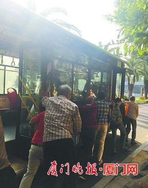 众人合力推公交车。